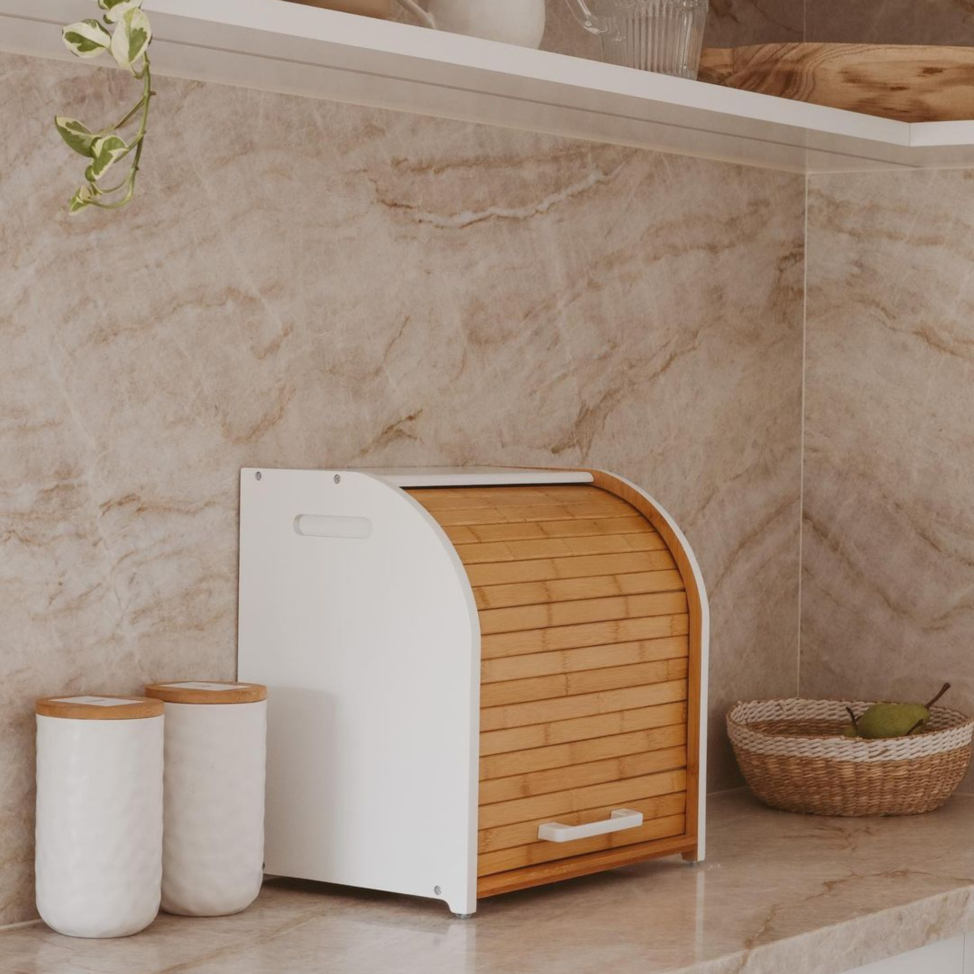 Kitchen counter with a breadbox, mugs, and decorative items.