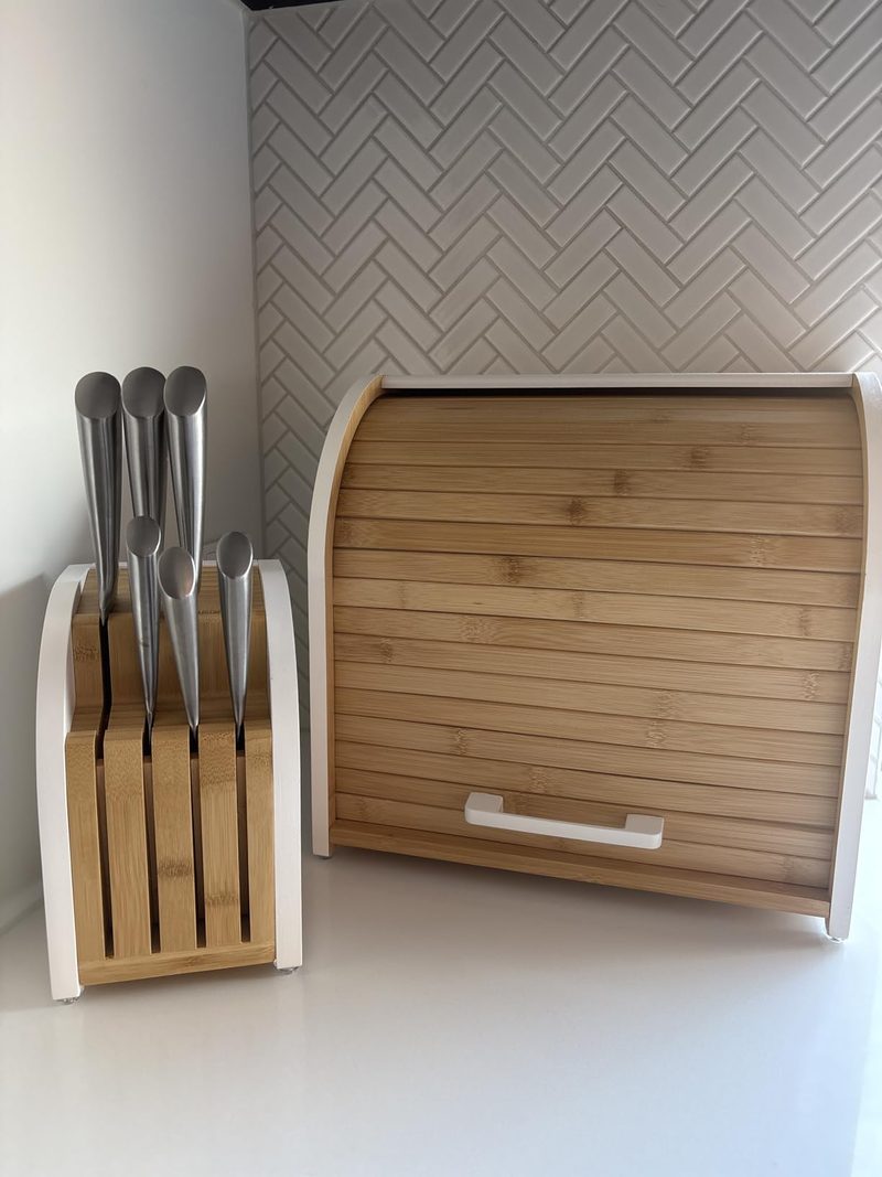Knife block beside the bamboo bread box on a white bench