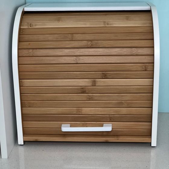 Closed bread box on a white bench