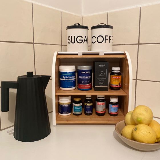 Bread box used for vitamins beside a kettle